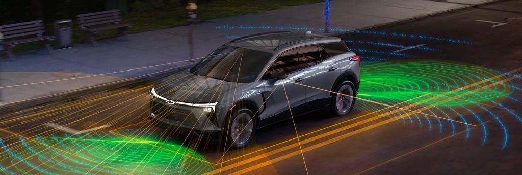 A Chevrolet electric SUV with digital sensor visuals showing its driver-assistance features.