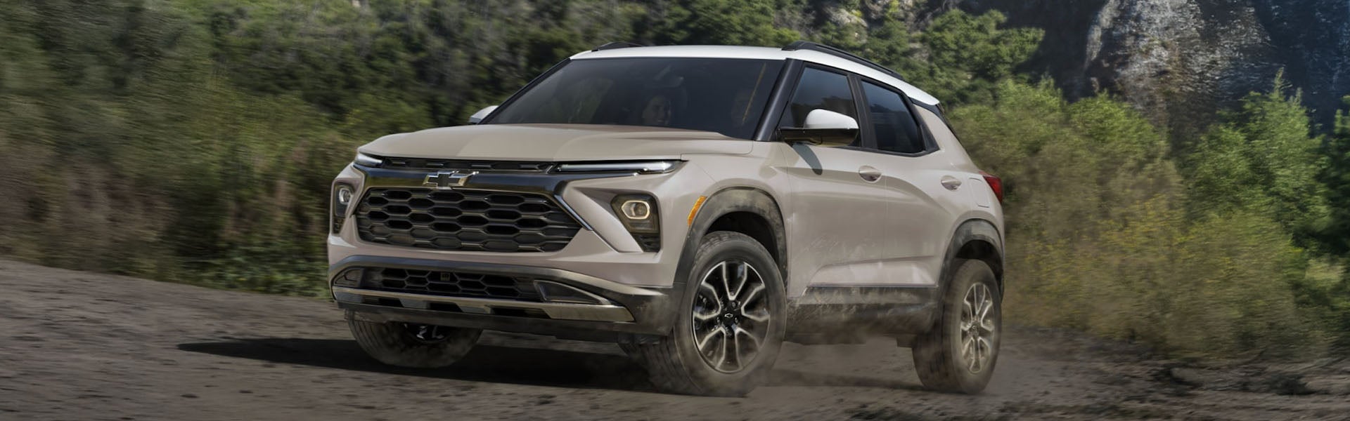 White Chevrolet Trax SUV driving on a dirt road.